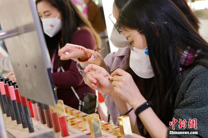 圖為女生正在體驗(yàn)口紅產(chǎn)品。 殷立勤 攝