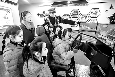 山東省榮成市公安局道路交通安全宣傳教育基地，交警帶領(lǐng)小學生現(xiàn)場體驗模擬駕駛。新華社發(fā)