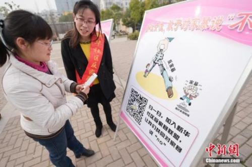 資料圖：今年3月8日，安徽合肥新華社區(qū)志愿者夏一瓊(右)向市民普及反家暴相關法律知識。鐘欣 攝