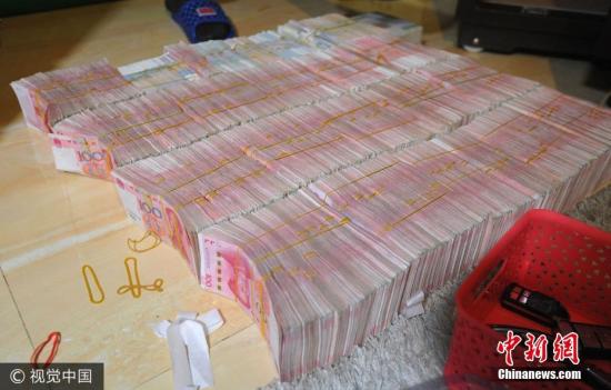 廣西南寧警方8月21日通報(bào)，當(dāng)?shù)亟粘晒善粕姘附痤~15.19億元人民幣的特大傳銷案件。圖為當(dāng)場繳獲的成捆現(xiàn)金。圖片來源：視覺中國