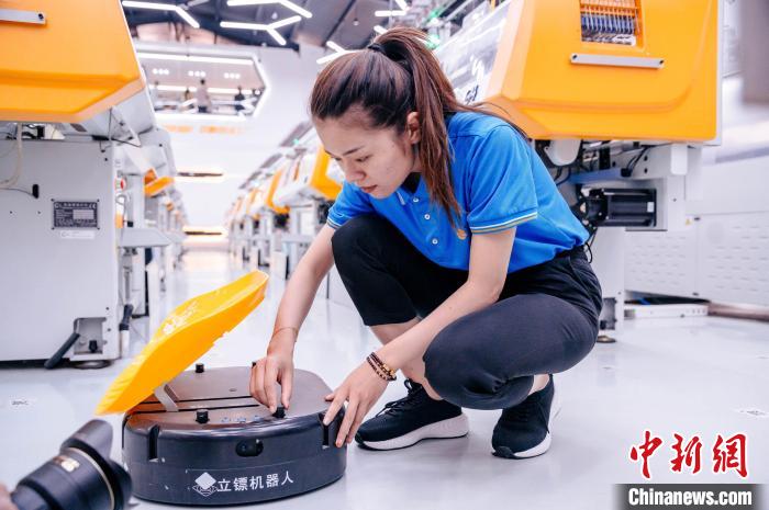 圖為員工在調(diào)試AGV搬運機器人?！±钅宪?攝